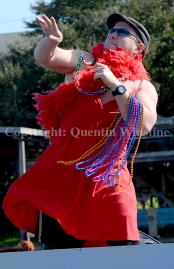 A Krewe of Bilge member on a boat float titled "Red Dress Run" tosses beads to the crowd along the Eden Isles canal in Slidell on Saturday, February 15, 2014.